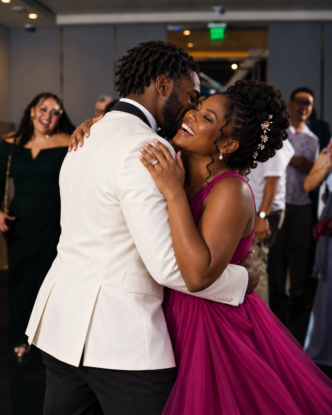 A newlywed couple sharing a joyful first dance, the bride laughing in a magenta gown as guests look on